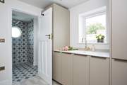 The utility area with an additional integrated fridge/freezer, washing machine and drier leading into the downstairs shower-room.