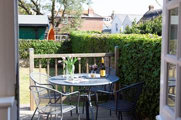 A charming enclosed garden with patio furniture and sun loungers