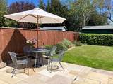 A charming enclosed garden with patio furniture and sun loungers 