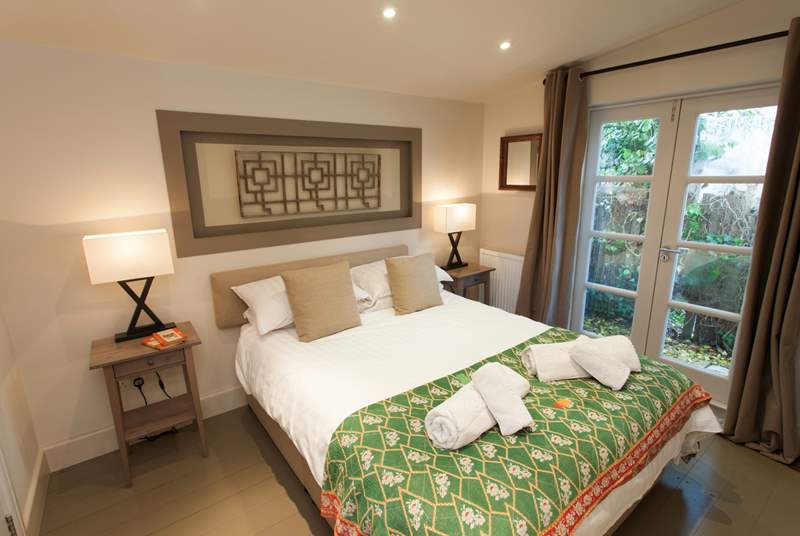 The master bedroom is a sanctuary, decorated for ultimate relaxation, with patio doors to let in the warm summer breeze.