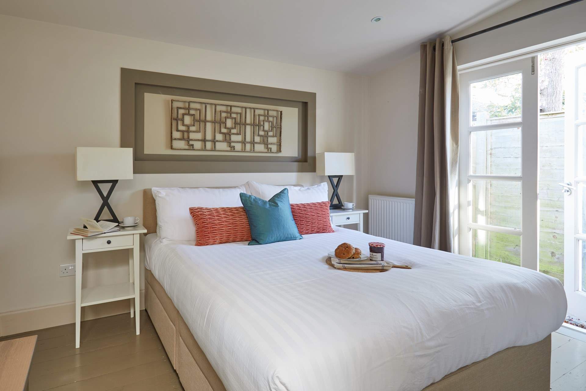 Bedroom 1 is designed for ultimate relaxation, with patio doors to let in the warm summer breeze.