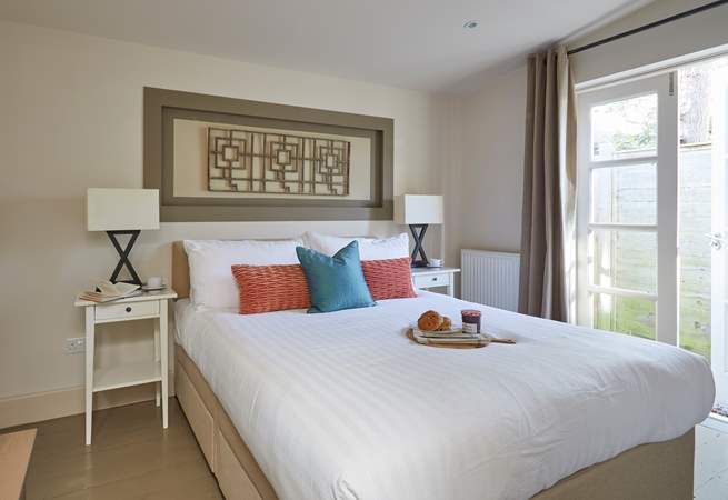 Bedroom 1 is designed for ultimate relaxation, with patio doors to let in the warm summer breeze.