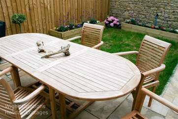 The garden furniture includes a charcoal barbecue.