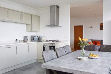 The open plan modern kitchen, dining area with view of the living room.