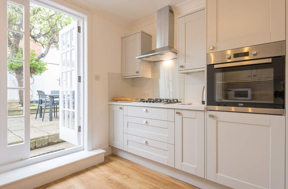 The kitchen has direct access to the rear enclosed patio with outdoor seating and an outdoor shower