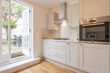 The kitchen has direct access to the rear enclosed patio with outdoor seating and an outdoor shower