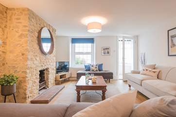 The light filled sitting/dining-room looks out to sea which is just over the road