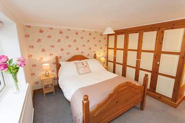 The quaint master bedroom has been thoughtfully decorated in keeping with the rest of the cottage.