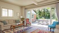 The sitting-room with wooden floors and kilim rugs. Enjoy the inviting view of the garden.