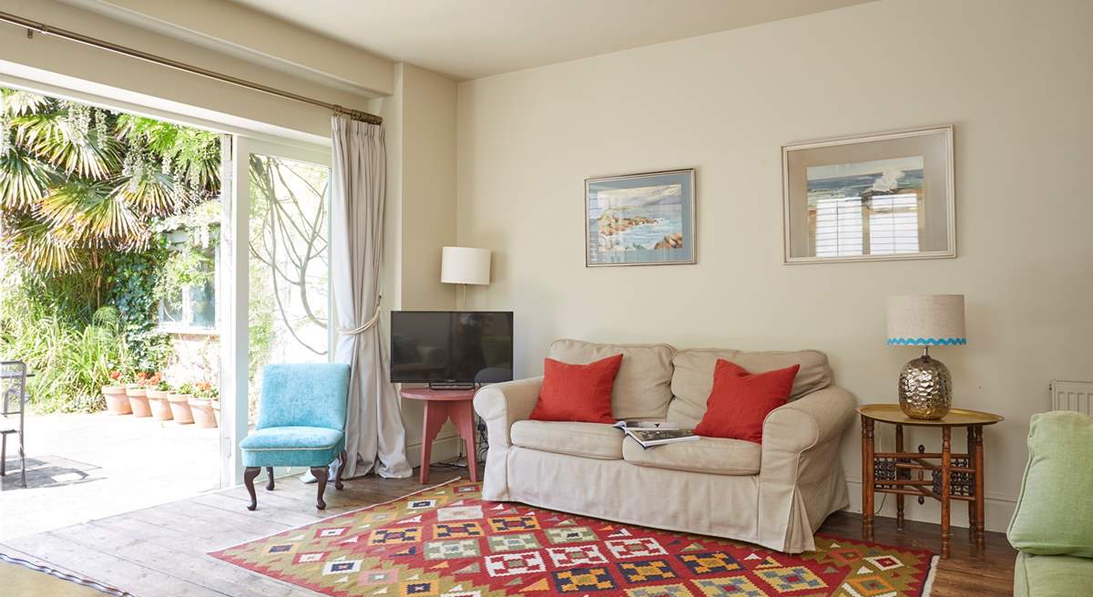 The sitting-room with open bi-fold doors bringing the outside in.