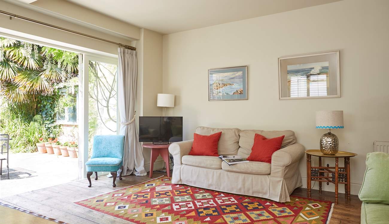 The sitting-room with open bi-fold doors bringing the outside in.