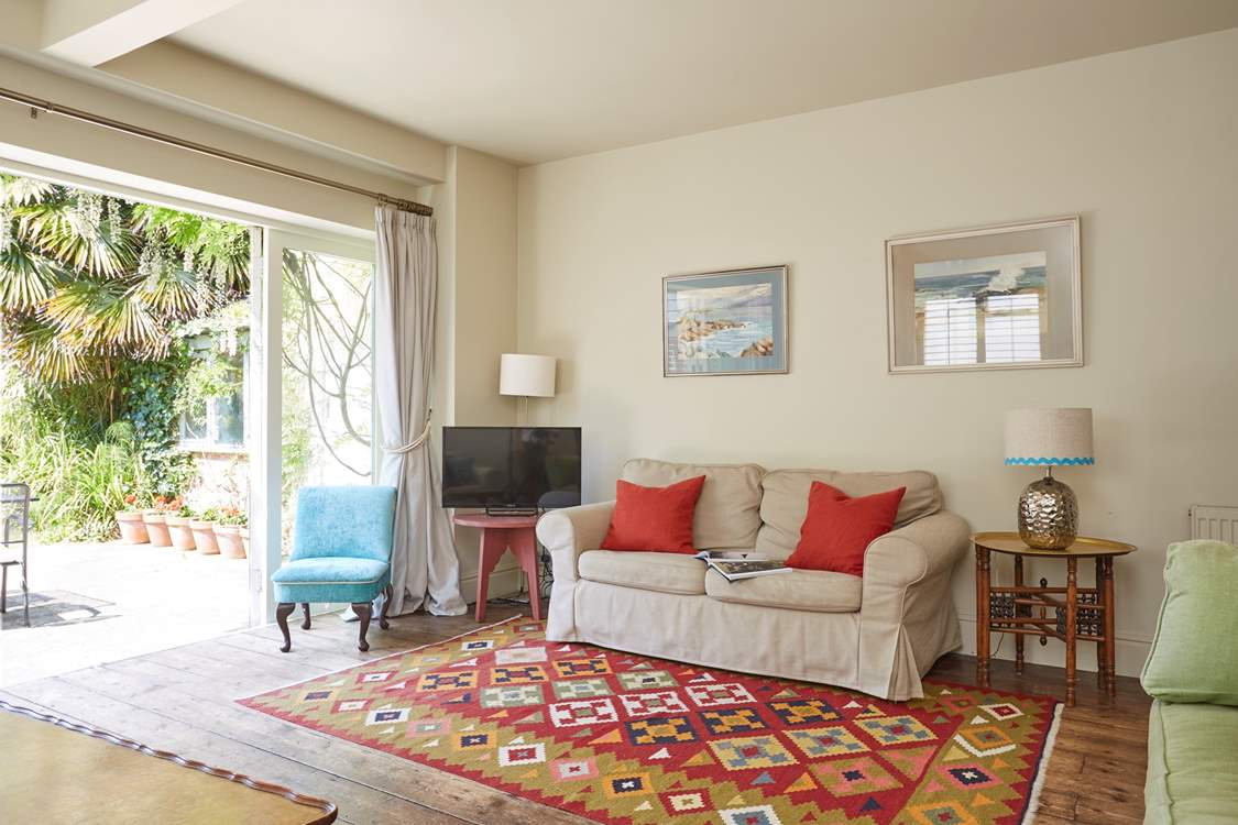 The sitting-room with open bi-fold doors bringing the outside in.