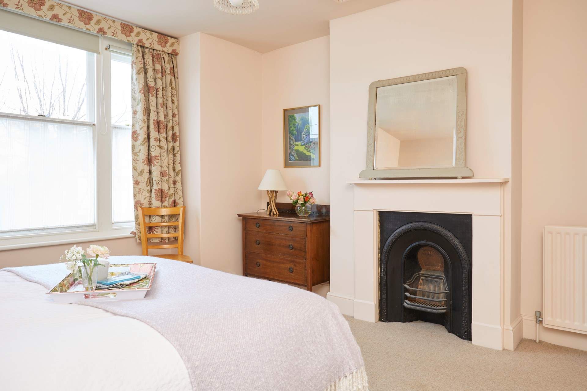 Spacious bedroom 1 with ornamental fireplace.