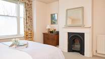Spacious bedroom 1 with ornamental fireplace.