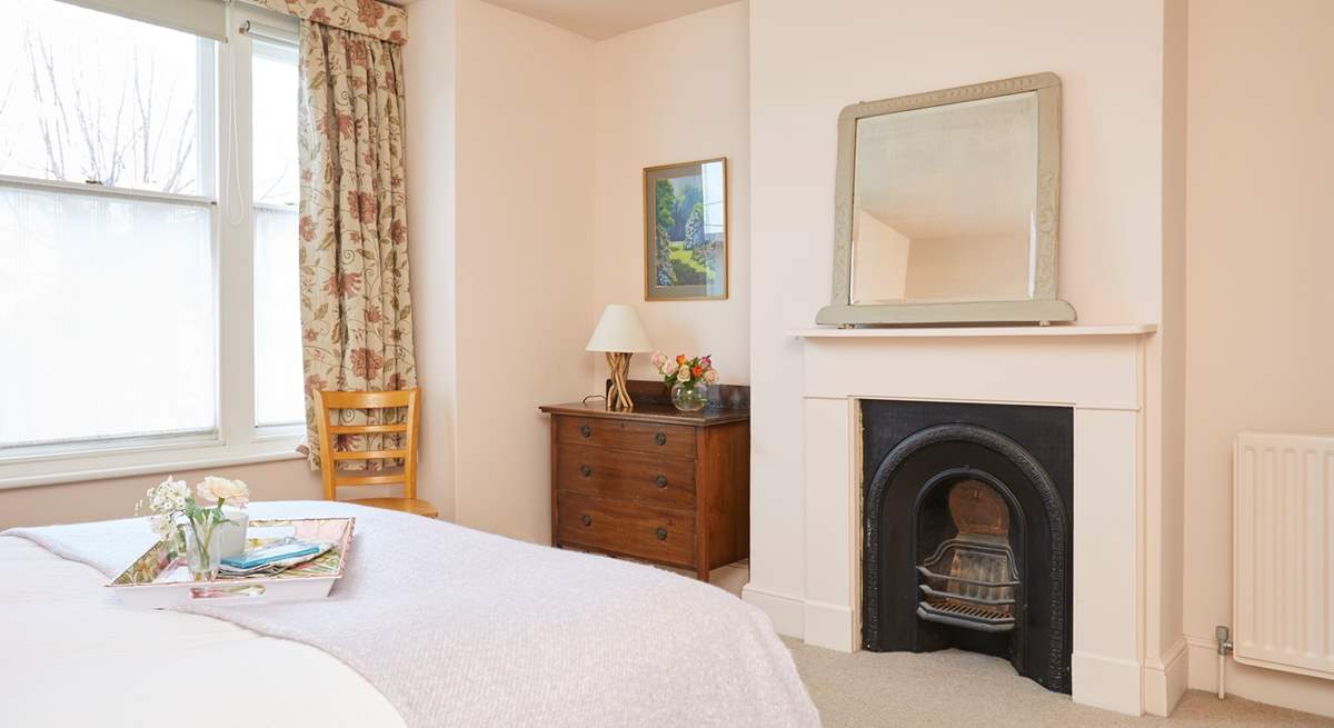 Spacious bedroom one with ornamental fireplace.