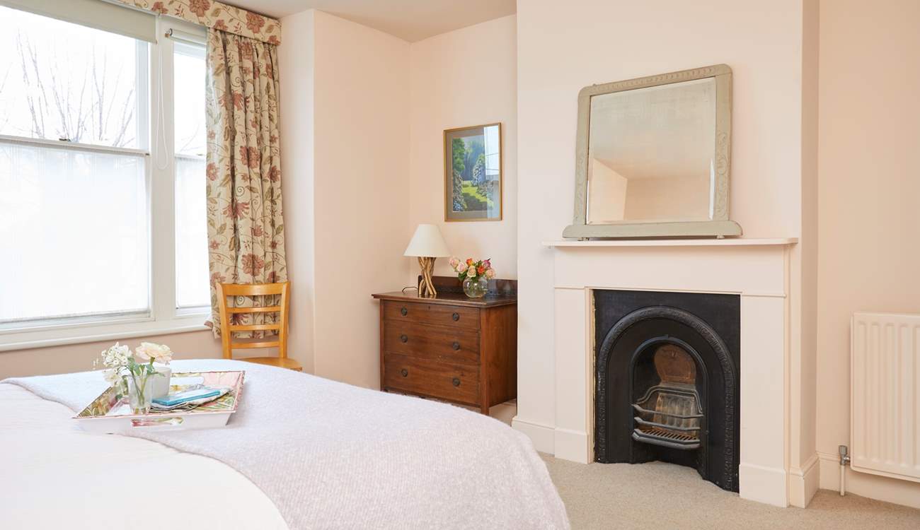 Spacious bedroom 1 with ornamental fireplace.