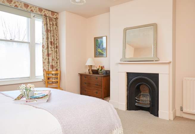 Spacious bedroom one with ornamental fireplace.