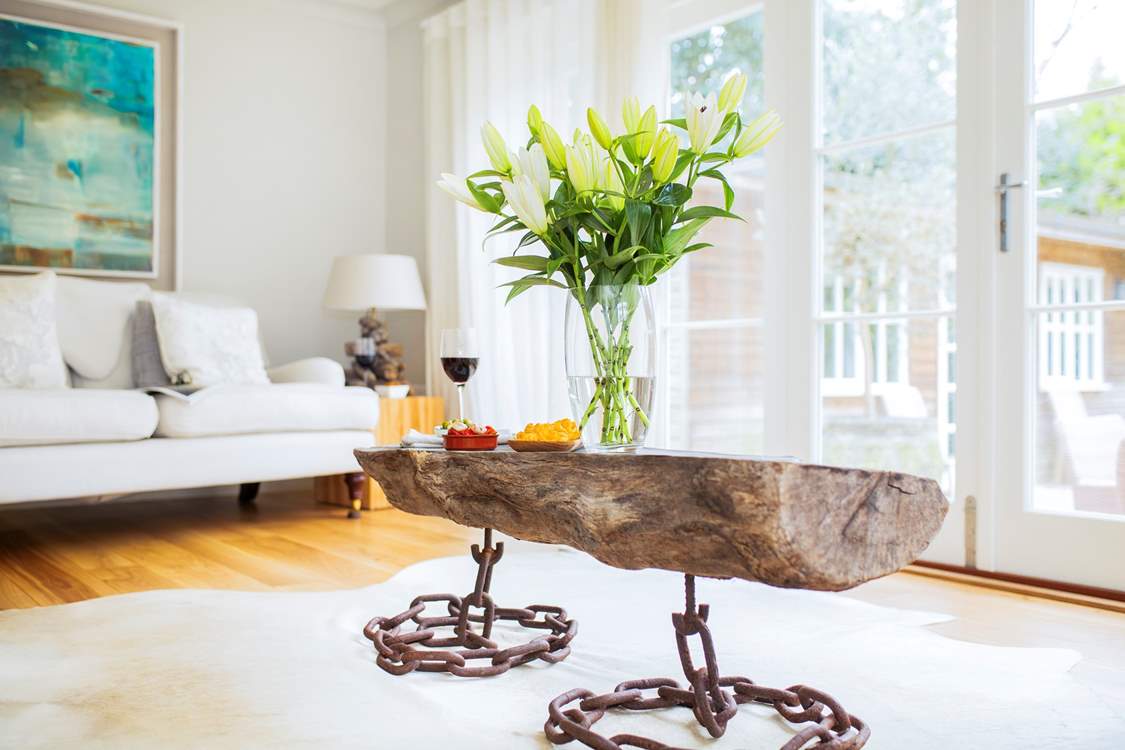 The elegant sitting room with comfortable sofas.  The  bi-fold doors lead out to the al fresco dining and games room.
