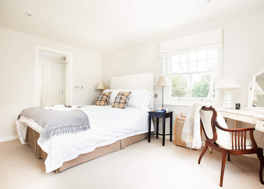 The en suite corner bedroom at the top of the stairs overlooks the front garden and the side patio.