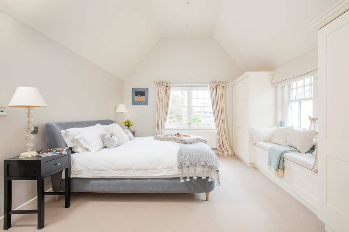 The impressive master bedroom with super-king size bed has views out to the front garden.