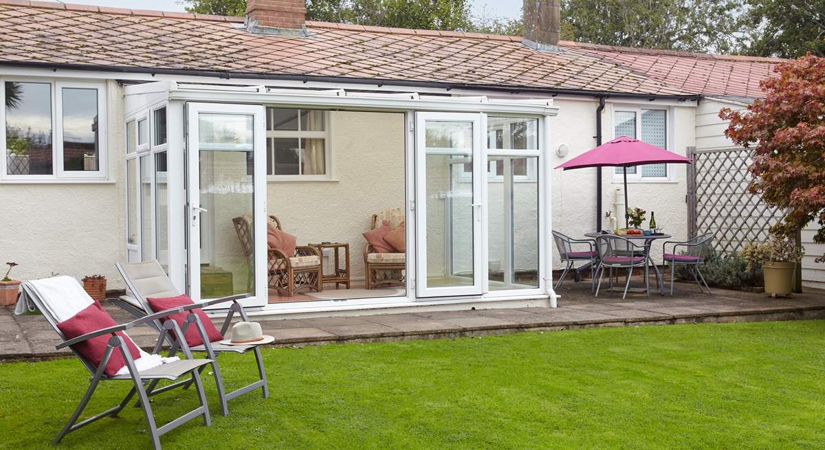 The garden with patio area and access into the sun-room.  