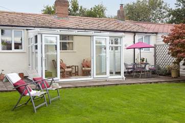The garden with patio area and access into the conservatory.