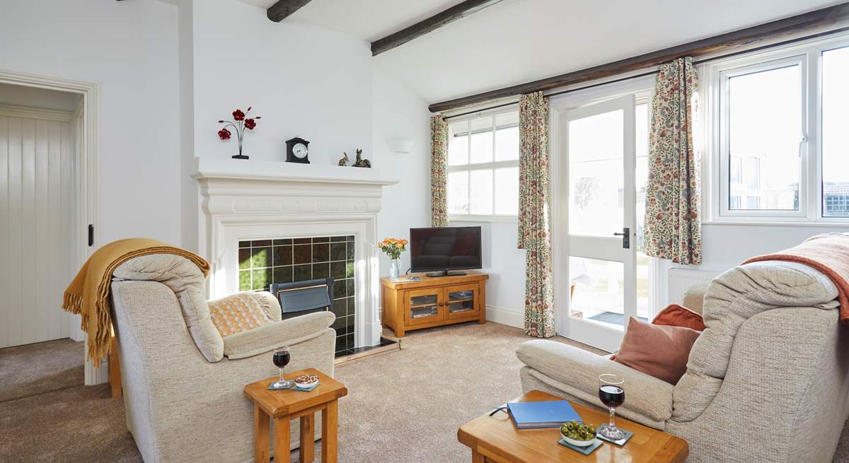 The spacious living room area leads on to the sun-room and garden.