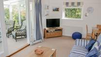 The comfortable sitting-room with doors into the sunny conservatory, a peaceful place to sit back and relax.