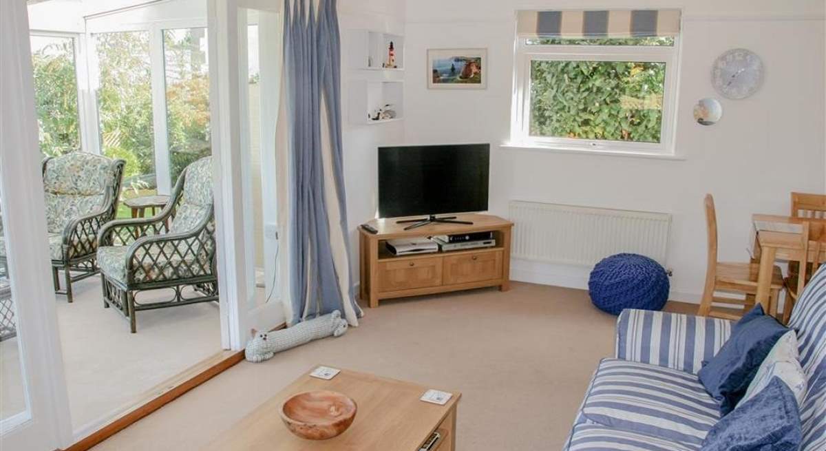 The comfortable sitting-room with doors into the sunny conservatory, a peaceful place to sit back and relax.