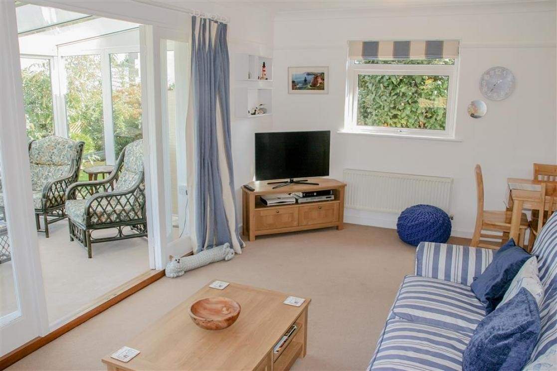 The comfortable sitting-room with doors into the sunny conservatory, a peaceful place to sit back and relax.