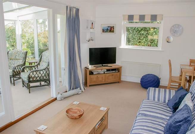 The comfortable sitting-room with doors into the sunny conservatory, a peaceful place to sit back and relax.