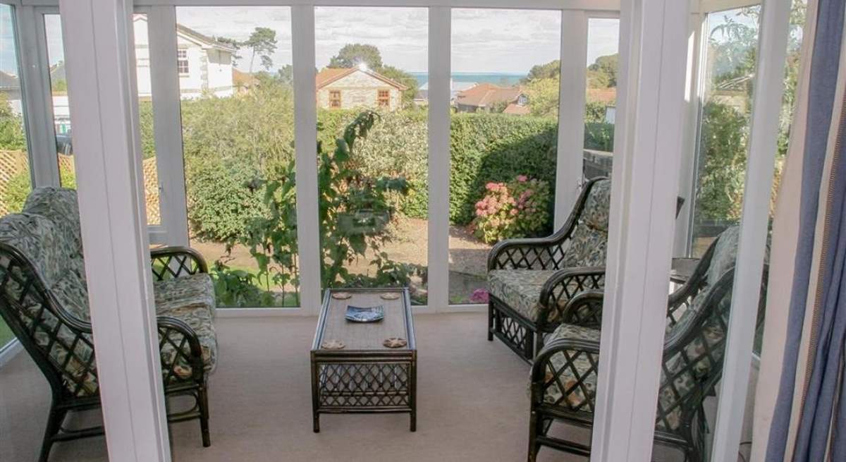 Lovely light and sunny conservatory with garden and sea views.