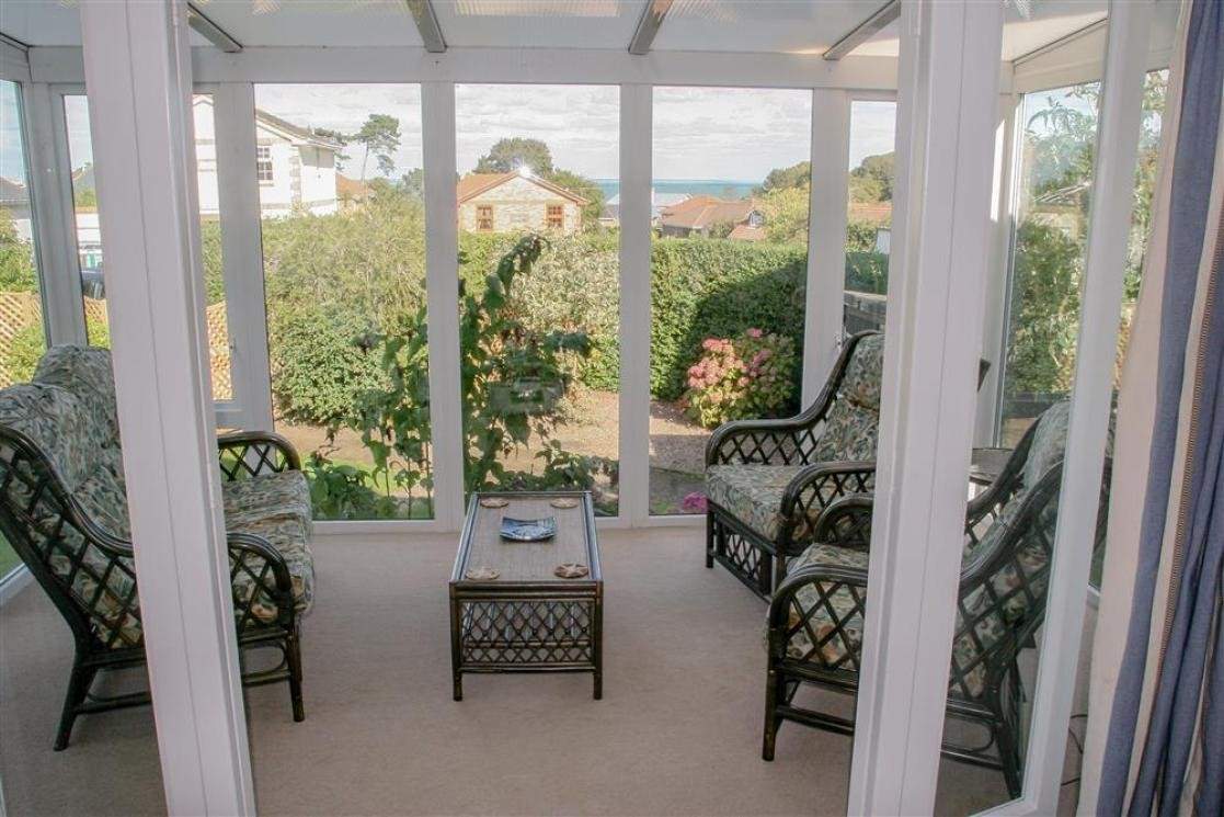 Lovely light and sunny conservatory with garden and sea views.