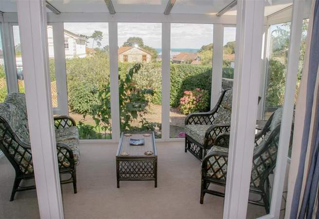 Lovely light and sunny conservatory with garden and sea views.