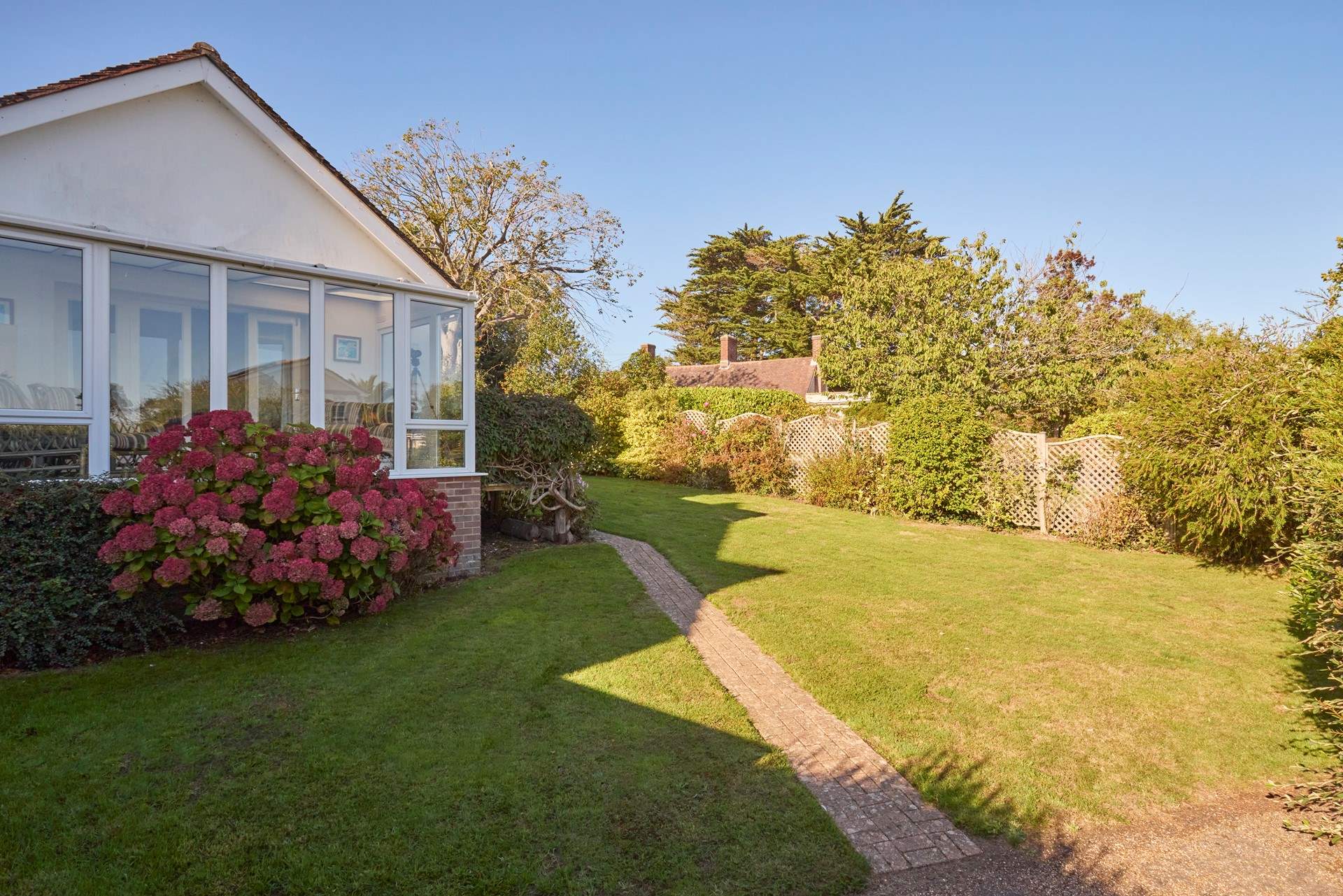 Sunny fully-enclosed garden at the front of the property.