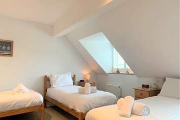 The second bedroom on the first floor is spacious with three single beds...