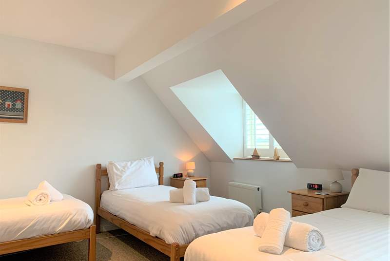 The second bedroom on the first floor is spacious with three single beds...
