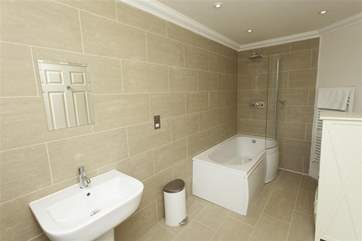 En suite bathroom to twin bedroom with shower over bath