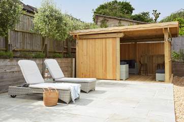 Relax with your loved ones between the sun loungers and summer house.