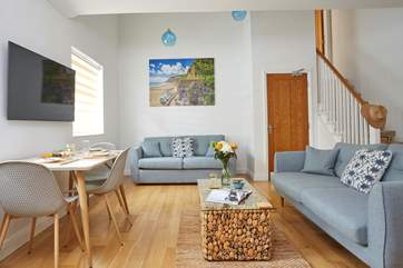 View of the bright and airy living space with steps leading up to the mezzanine bedroom.