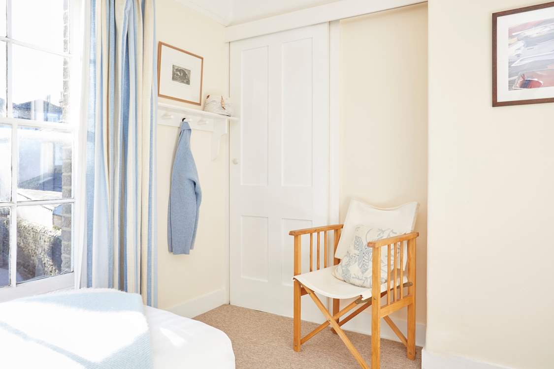 Twin bedroom with deck chair and large built in wardrobe.