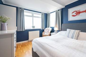 The first bedroom to the front of the property showcases sea views.