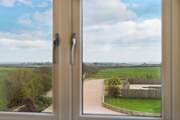 The view from the upstairs bedroom looking across the front garden and pool area towards Lizard Point.