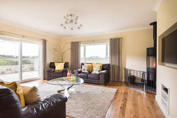 The dual-aspect sitting-room with comfy sofas and chairs for all.