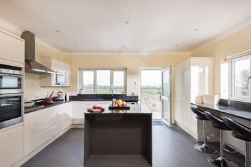A spacious kitchen with breakfast-bar and central island completes this very stylish kitchen.