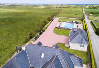 An aerial shot of the house, garage and pool all the way out to sea.