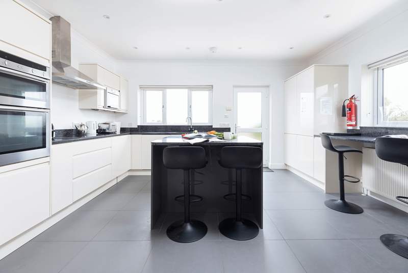 A spacious kitchen with breakfast-bar and central island completes this very stylish kitchen.