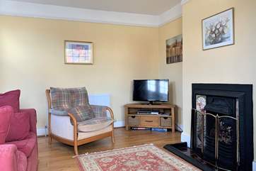 The sitting-room is a comfortable haven with a cosy fireplace.