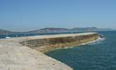 The iconic Cobb at nearby Lyme Regis, where you will also find a beach, summer water sports hire, fishing trips, and great places to eat and drink. - Thumbnail Image