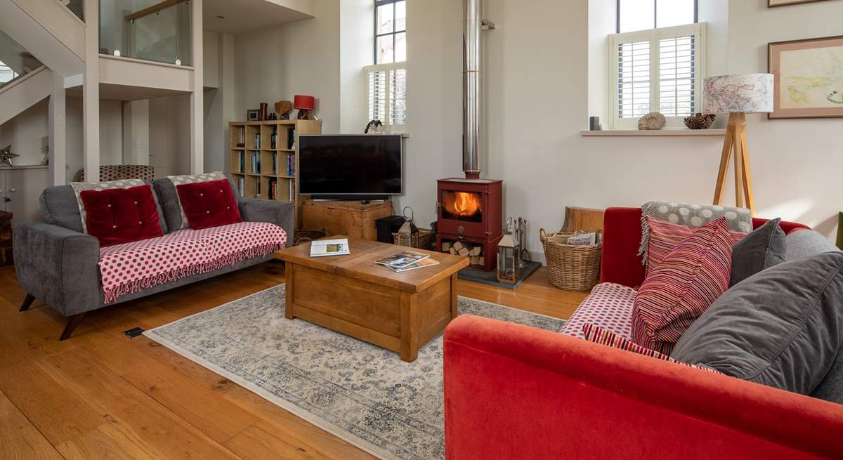 This wonderful open plan sitting-room has a cosy wood-burner for cooler evenings.